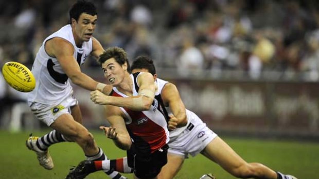 St Kilda's stand-in captain Lenny Hayes handballs clear of Dockers Ryan Crowley (left) and Anthony Morabito last night.