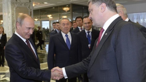 Shake on it: Russian President Vladimir Putin meets with Ukrainian President Poroshenko for the first time since June.