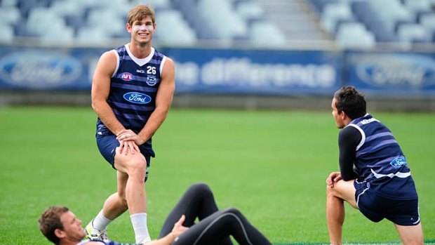 Cats purring: Things were pretty relaxed at Geelong training yesterday as Cameron Mooney, Tom Hawkins and Mathew Stokes enjoyed a stretch and a chat.