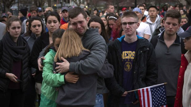 Grief: Scott Turner is hugged by friends at a vigil for bomb victims.