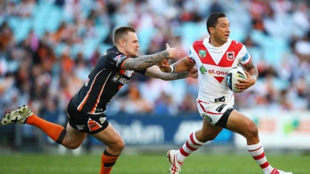 On a winning team: Dragons signing Benji Marshall fends off a Wests Tigers tackle on the anniversary of his NRL debut.