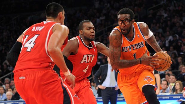 Knicks forward Amar'e Stoudemire drives past Paul Millsap and Gustavo Ayon  of the Atlanta Hawks at Madison Square Garden.
