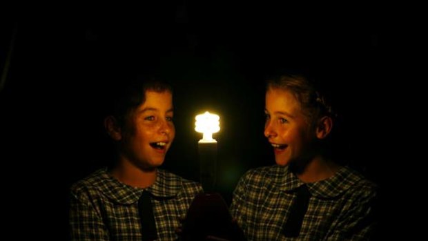 Earth Hour ...  students  Beatrix Hardy and  Scarlett Hardy with an energy efficient light bulb  at Hamilton South Public School in Newcastle.