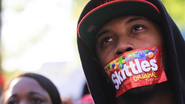 Growing anger &#8230; his mouth covered, university student Jajuan Kelley joins a rally in Atlanta on Monday over the death of Trayvon Martin.