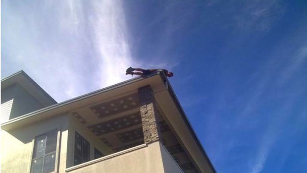 A photo posted on Facebook of a man planking on a roof.