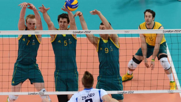 Italy's Ivan Zaytsev spikes as, from left,  Harrison Peacock, Travis Passier and Adam White attempt to block.