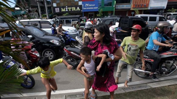 People in Banda Aceh run shortly after a powerful earthquake hit western coast of Sumatra, prompting an Indian Ocean-wide tsunami alert.