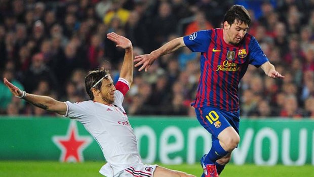 Barcelona's forward Lionel Messi is tackled by AC Milan defender Luca Antonini before he is awarded a penalty.