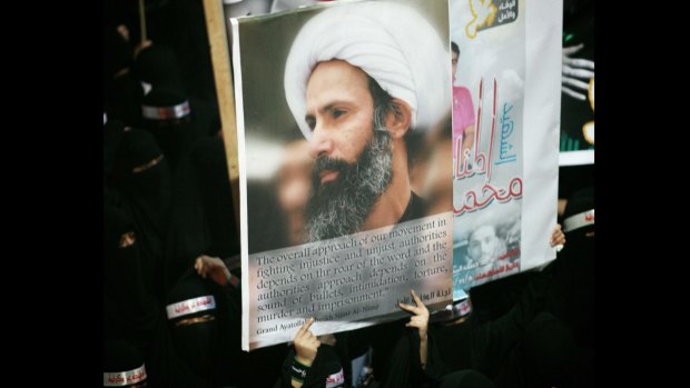 A Saudi protester carries a poster of jailed cleric Nimr Baqir al-Nimr at a demonstration in the eastern Saudi town of al-Awamiya in September 2012.
