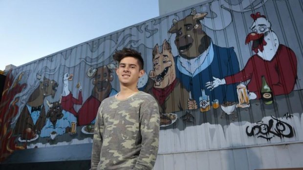 Solomon Grainger, 16, with the feature artwork in the courtyard of Hopscotch bar in Braddon.