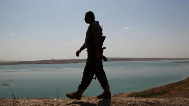 A Peshmerga fighter patrols near Mosul dam at the town of Chamibarakat.