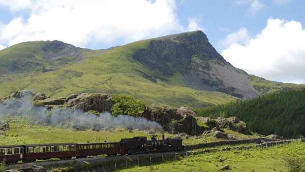 A steam train travels through Snowdonia National Park, North Wales.