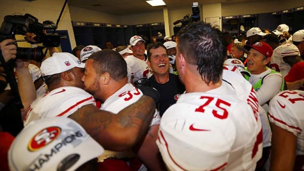 San Francisco 49ers and their head coach Jim Harbaugh celebrate in the locker room after their win.