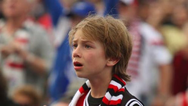 A young Saints fan at O'Donnell Gardens in St Kilda absorbs the fact that the match has ended in a draw.