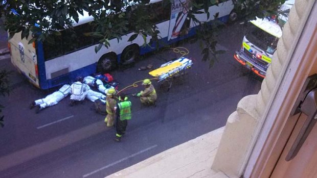 Trapped under a bus: paramedics treat the woman.