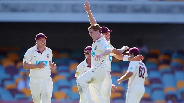 Alister McDermott of the Bulls celebrates after claiming one of his four opening day wickets in the Sheffield Shield final at the Gabba.