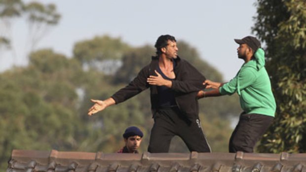 Detainees scuffle on the roof at Villawood.