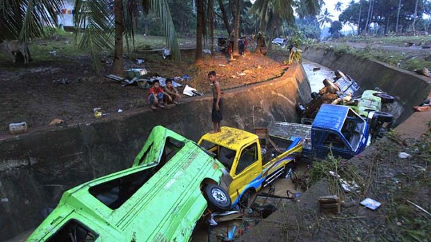Damaged vehicles washed away by flash floodsfrom Typhoon Washi lie in a ditch in Cagayan de Oro, southern Philippines.