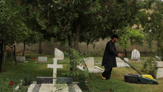 Abdul Sami mows the lawn near the grave of Sir Marc Aurel Stein in the British Christian Cemetery in Kabul.