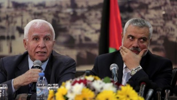 Gaza's Hamas PM Ismail Haniyeh, right, listens to senior Fatah official Azzam al-Ahmed, left, after the announcement of the agreement between the two rival Palestinian groups.