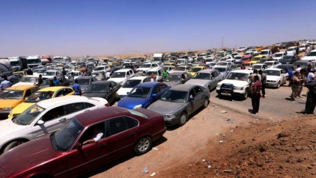 Iraqis fleeing the violence in Mosul wait in their vehicles at a checkpoint run by Kurdish forces.