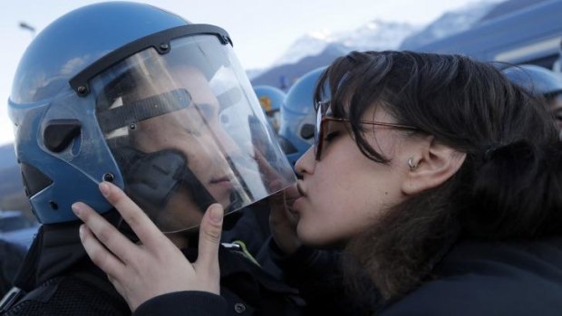 Provocative gesture: Protester Nina De Chiffre kisses the riot officer's visor.