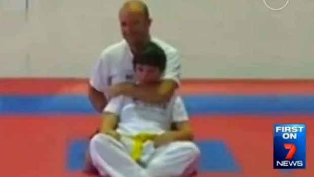 Michael Landas is shown applying a "sleeper hold" on one of his students, Crystal Trost.