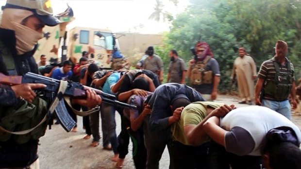 Islamic State militants lead away captured Iraqi soldiers after capturing a base in Tikrit, Iraq. 