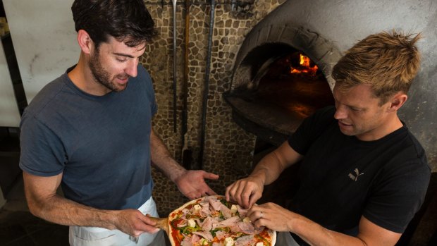 Mitchell puts the finishing touches on his favourite pizza: tomato sauce, basil, ham, chilli, capsicum, bocconcini and oregano. 