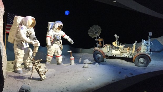 A scene on the Moon, with two astronauts alongside a lunar rover.