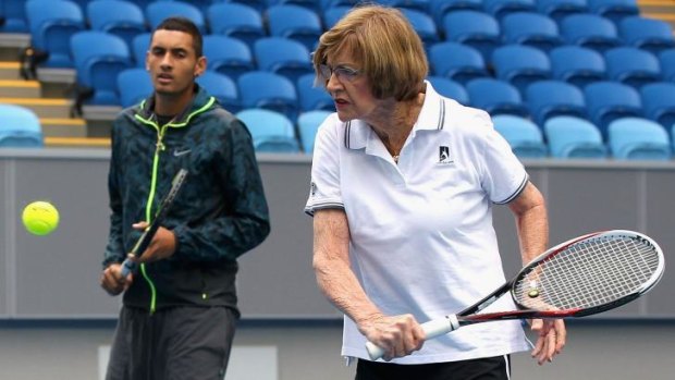 Margaret Court slices a backhand as Nick Kyrios looks on.