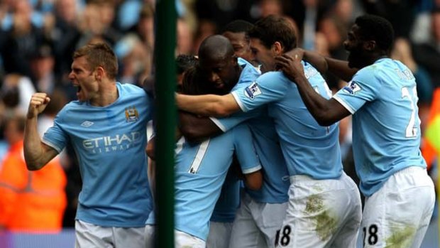 Carlos Tevez of Manchester City is mobbed after scoring the winner against Chelsea.