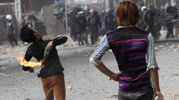 A worker throws a petrol bomb after clashes broke out during the garment workers protest.