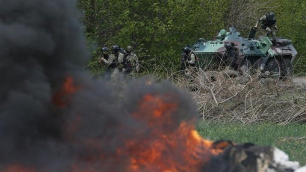 Ukrainian security force officers at a checkpoint set on fire and left by pro-Russian separatists near Slaviansk.