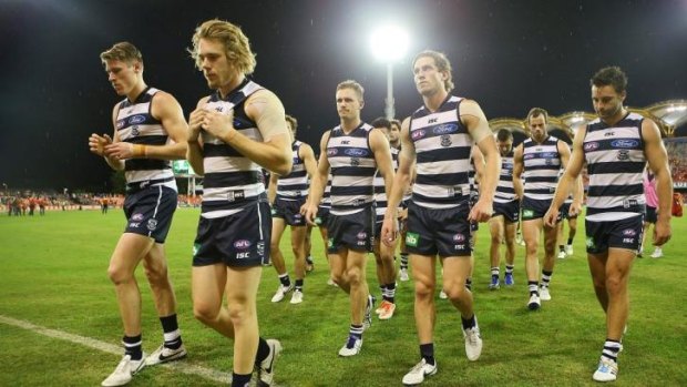 The Cats trudge off Metricon Stadium after their loss to the Suns on Saturday.