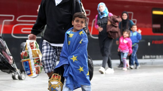 A migrant boy wrapped in an EU flag arrives from Austria at Munich Hauptbahnhof main railway station in Munich, Germany. 