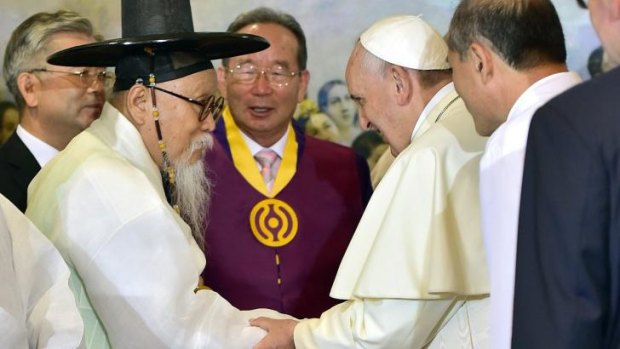 Pope Francis talks with Han Yang-won, chairman of the Association for Korean Native Religion, as he meets with South Korea's religious leaders at Myeong-dong Cathedral in Seoul.