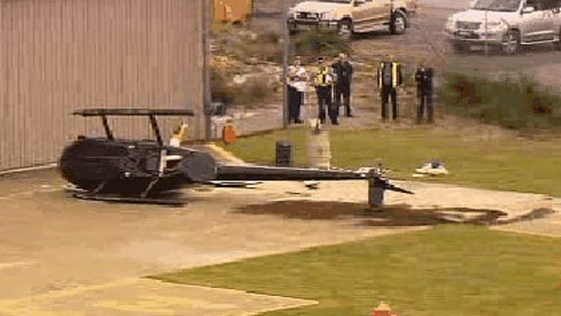 The crashed helicopter lies on its side at Jandakot Airport.