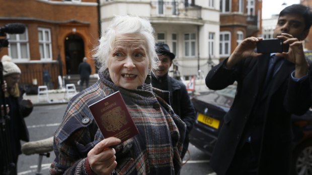 British Fashion designer Vivienne Westwood shows her passport to the media as she arrives outside the Ecuadorean embassy in London on Thursday.