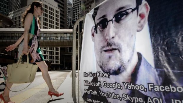 A woman walks past a banner displayed in support of US whistleblower Edward Snowden in Hong Kong.
