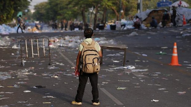 A school boy watches a protest rally from a distance in Bangkok, Thailand. 