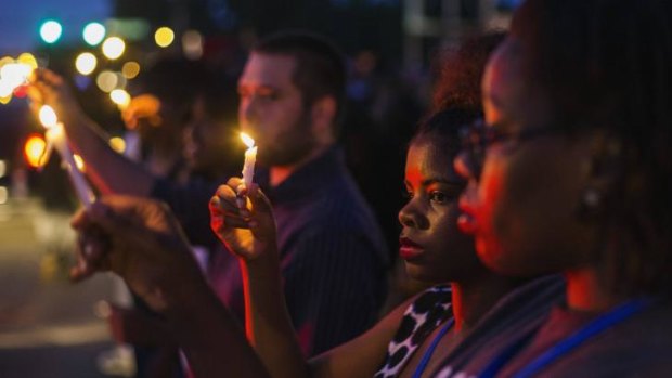 Protesters hold candles during a peaceful demonstration, as communities react to the shooting of Michael Brown in Ferguson, Missouri.