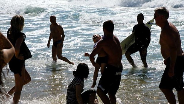 A child is carried to safety after being pulled from a rip at Bronte Beach.
