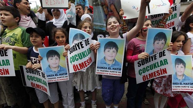Face of a revolution ... Syrian children carry pictures of 13-year-old Hamza al-Khatib  during a protest near the Syrian Consulate in Istanbul.