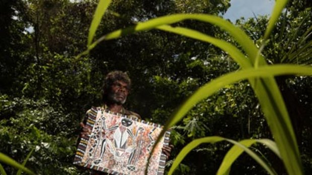 Living rough... a long grasser, Russel Ashley, with one of his artworks. Homeless people in Darwin are being given brushes and canvasses and encouraged to paint.