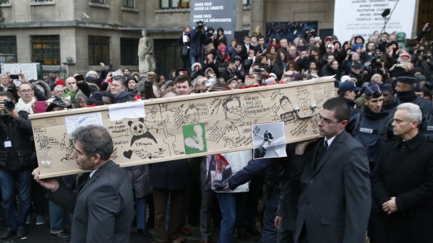 Pallbearers carry the casket of Charlie Hebdo cartoonist Bernard Verlhac, known as Tignous, decorated by friends and colleagues of the satirical newspaper Charlie Hebdo, at the city hall of Montreuil, on the outskirts of Paris.