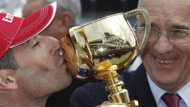 Trainer Alain de Royer-Dupre (right), of France, watches as jockey Gerald Mosse kisses the trophy after riding Americain to victory in last year's Melbourne Cup.