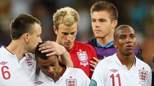 Ashley Cole and Ashley Young are consoled by teammates after England's loss to Italy.