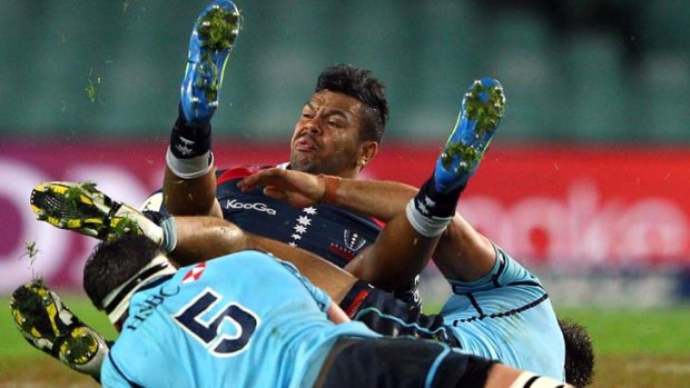 Awkward reunion &#8230; Rebels fullback Kurtley Beale is given some unceremonious treatment by a pair of Waratahs during his first match against his former teammates on Saturday.