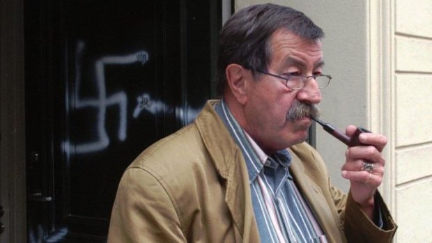 German author Günter Grass in front of his house after it was smeared by swastikas in 1997. 